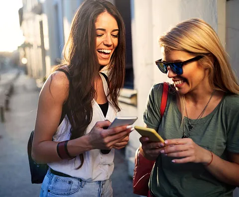 Junge Frau freut sich über Ihr gebrauchtes Handy